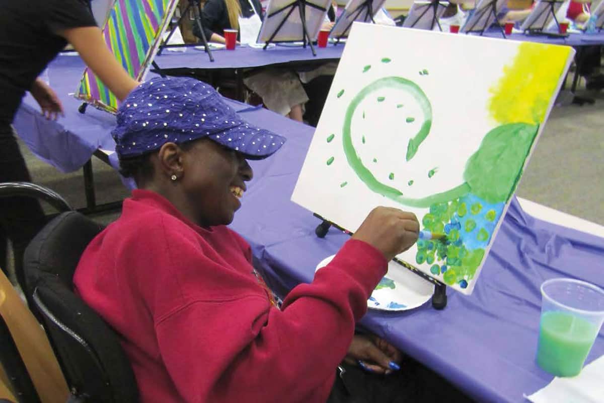 Tracy Bradshaw participates in a Paint Night fundraiser at the Denali Center.