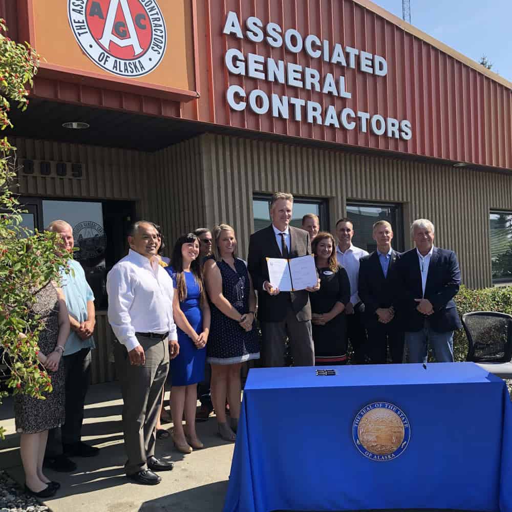 AGC members stand with Alaska Governer Mike Dunleavy for a photo at a signing event