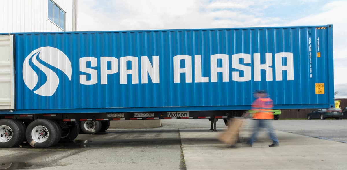 Container truck with blurred man pushing dolly