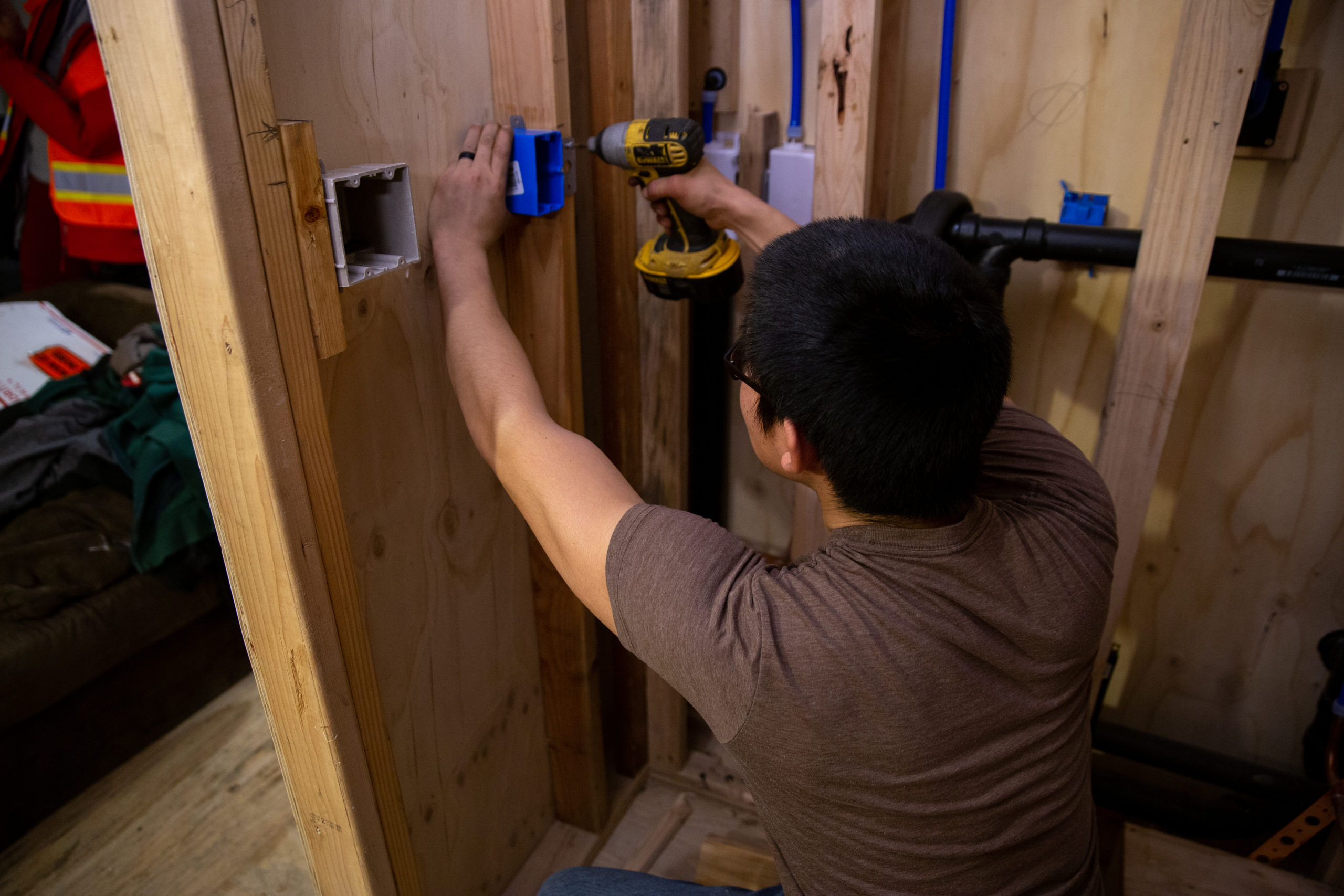 An ANTHC worker installs electrical wiring and indoor plumbing in a house in Eek in 2019.