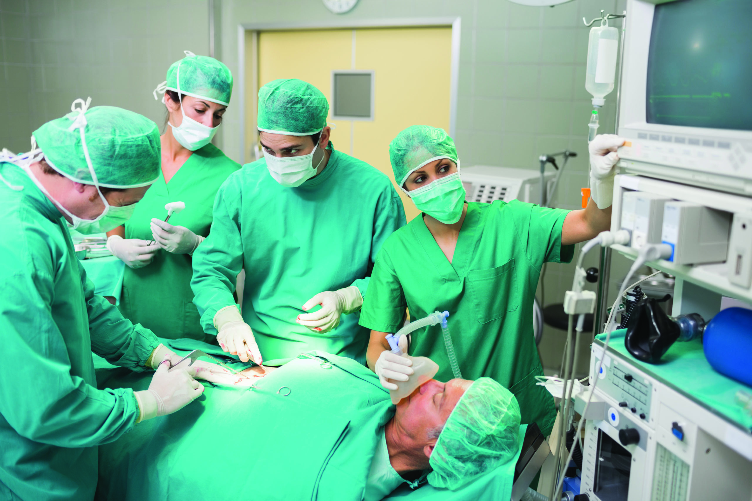Nurse adjusting a monitor next to patient