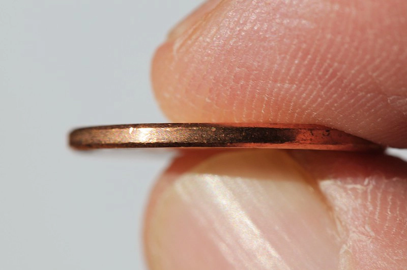 penny in finger